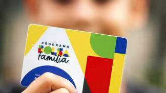 Homem com cartão Bolsa Família na mãos