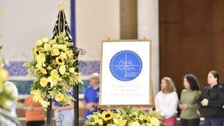 logo academia marial ao lado da Imagem de Nossa Senhora Aparecida