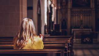 mulher rezando na igreja
