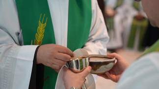 padre com a hóstia e o vinho consagrados em missa