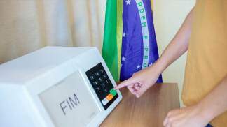 pessoa apertando o confirma na urna eletronica