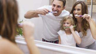 Família em frente ao espelho escovando os dentes